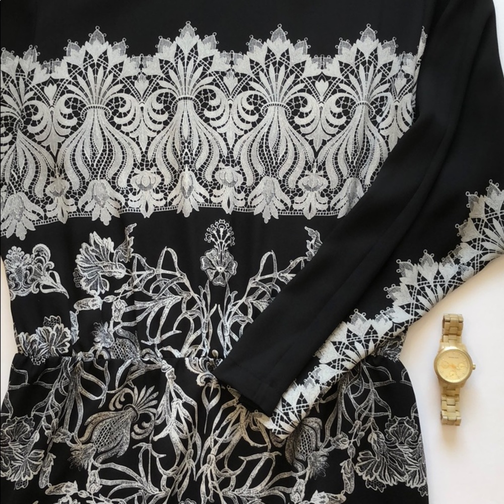 Sheer black dress with white design.